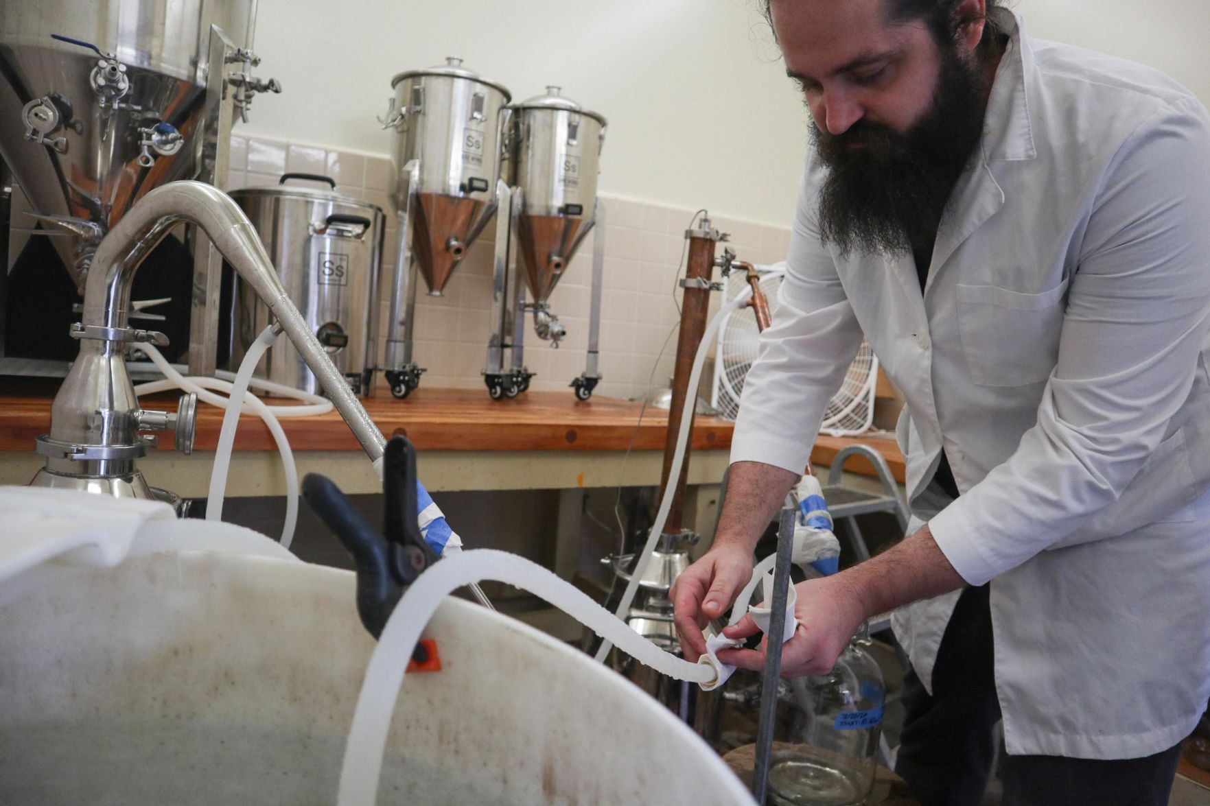 CEO Nicolas Cetraro checks on the fermentation process of the hand sanitizer